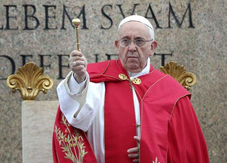 Pope Francis sprinkles holy water with an aspergillum as a blessing during the Palm Sunday mass at Saint Peter&#039;s Square at the Vatican April 13, 2014. REUTERS/Alessandro Bianchi