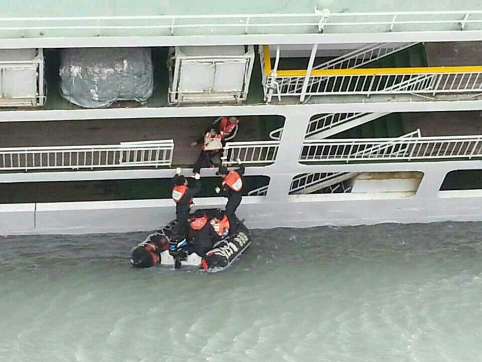 A passenger is rescued by South Korean maritime policemen from a sinking ship in the sea off Jindo April 16, 2014, in this picture provided by West Regional Headquarters Korea Coast Guard and released by News1. About 160 passengers, including high school 