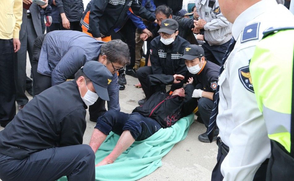 ATTENTION EDITORS - VISUAL COVERAGE OF SCENES OF INJURY OR DEATH An injured passenger rescued by South Korean maritime policemen from a sinking ship in the sea off Jindo, is treated at a port in Jindo April 16, 2014. About 160 passengers, including high s