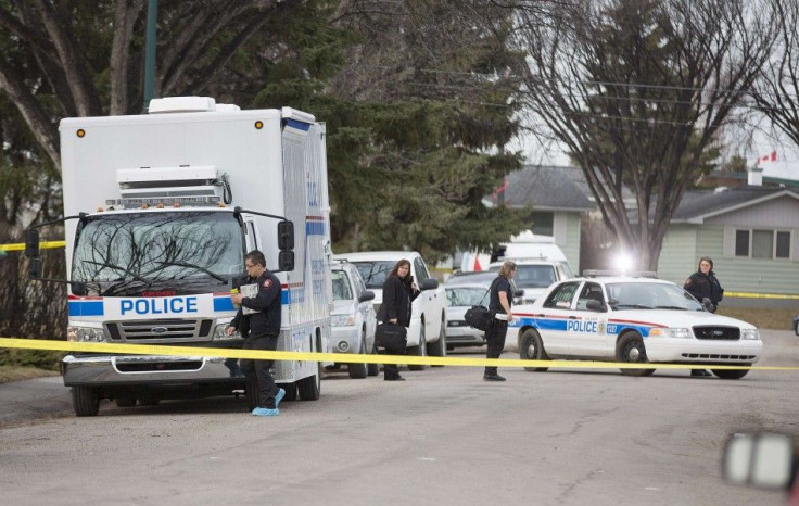 Police prepare to enter a house where five people were stabbed in the early morning hours in Calgary, Alberta, April 15, 2014. Three people died on the scene of the crime while two others died in hospital. The police have one person in custody. REUTERS/To