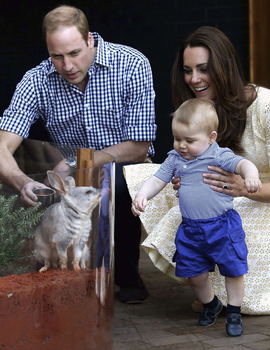 Britains Catherine, Duchess of Cambridge, holds her son George, next to her husband Prince William as they meet a bilby named George after the young prince, at Taronga Zoo in Sydney