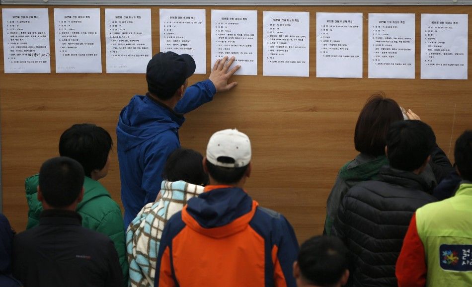 Family members look at a noticeboard with descriptions of bodies recovered from the capsized passenger ship Sewol at the port in Jindo April 22, 2014. The crew of the South Korean ferry that sank with hundreds of people on board repeatedly asked officers 
