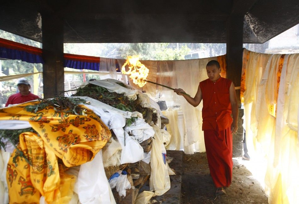 A Buddhist monk sets fire to the body of Ankaji Sherpa, who lost his life in an avalanche at Mount Everest last Friday, during the cremation ceremony of Nepali Sherpa climbers in Kathmandu April 21, 2014. Nepals Sherpas have demanded compensation of 10,