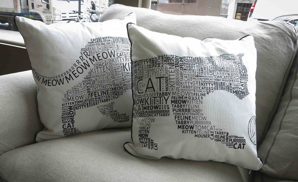 Two sofa cushions that go together to make an image of a cat is pictured at the cat cafe in New York