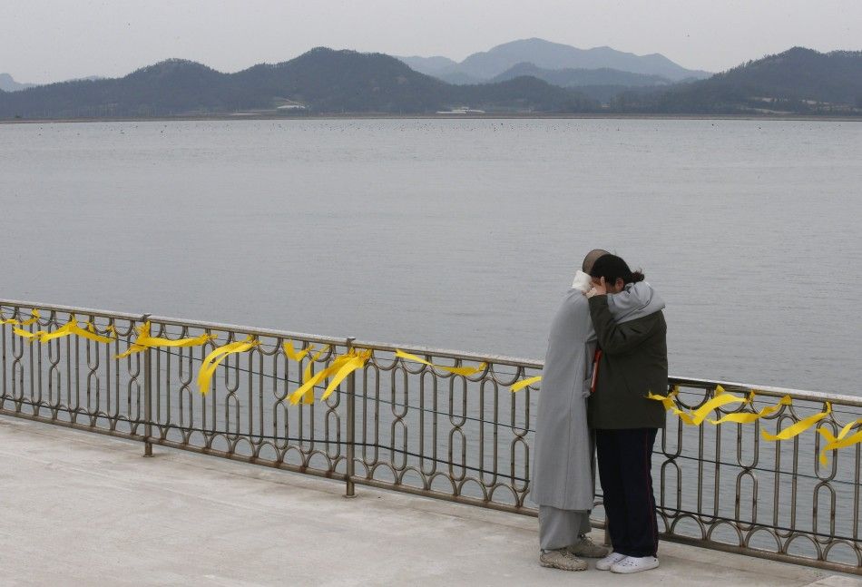 A Buddhist nun comforts the crying family member of a missing passenger onboard the capsized Sewol ferry at a port in Jindo April 26, 2014. More than 300 people, most of them students and teachers from the Danwon High School, are dead or missing presumed 