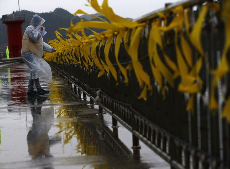 A volunteer supporting family members of missing passengers onboard the capsized Sewol ferry looks at yellow ribbons dedicated to the victims at a port in Jindo April 27, 2014. South Korean Prime Minister Chung Hong-won announced his resignation on Sunday
