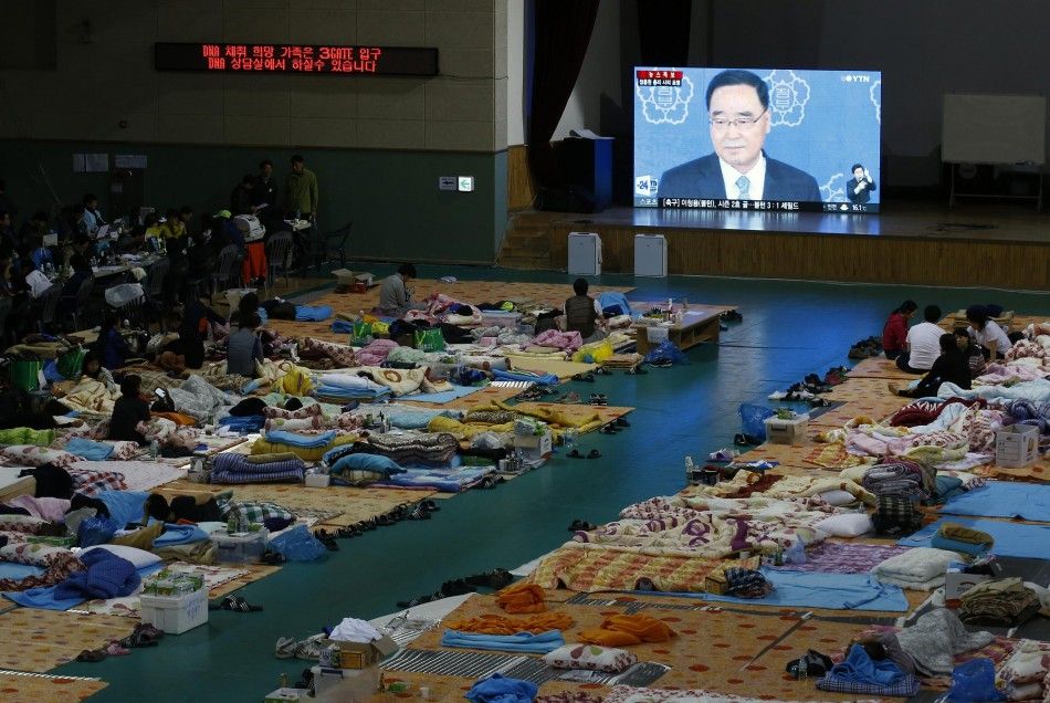 Family members of missing passengers onboard the sunken South Korean ferry Sewol watch a large monitor screen broadcast South Korean Prime Minister Chung Hong-won announcing his resignation at a makeshift accommodation at a gymnasium in Jindo April 27, 20