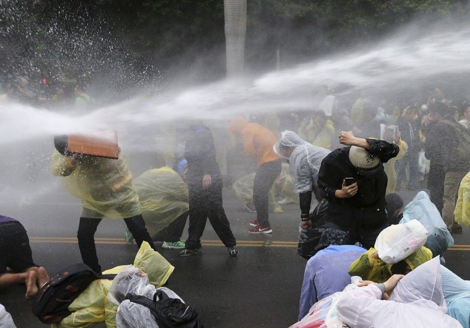 REFILE - CORRECTING GRAMMAR   Police use a water cannon to disperse demonstrators protesting the construction of a fourth nuclear plant, in front of Taipei Railway station in Taipei April 28, 2014. The Taiwan government will halt construction at the islan