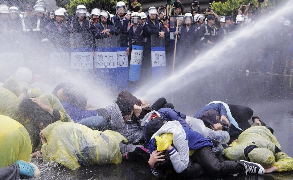 Police use a water cannon to disperse demonstrators protesting the construction of a fourth nuclear plant, in front of Taipei Railway station in Taipei April 28, 2014. The Taiwan government will halt construction at the islands fourth nuclear power plant