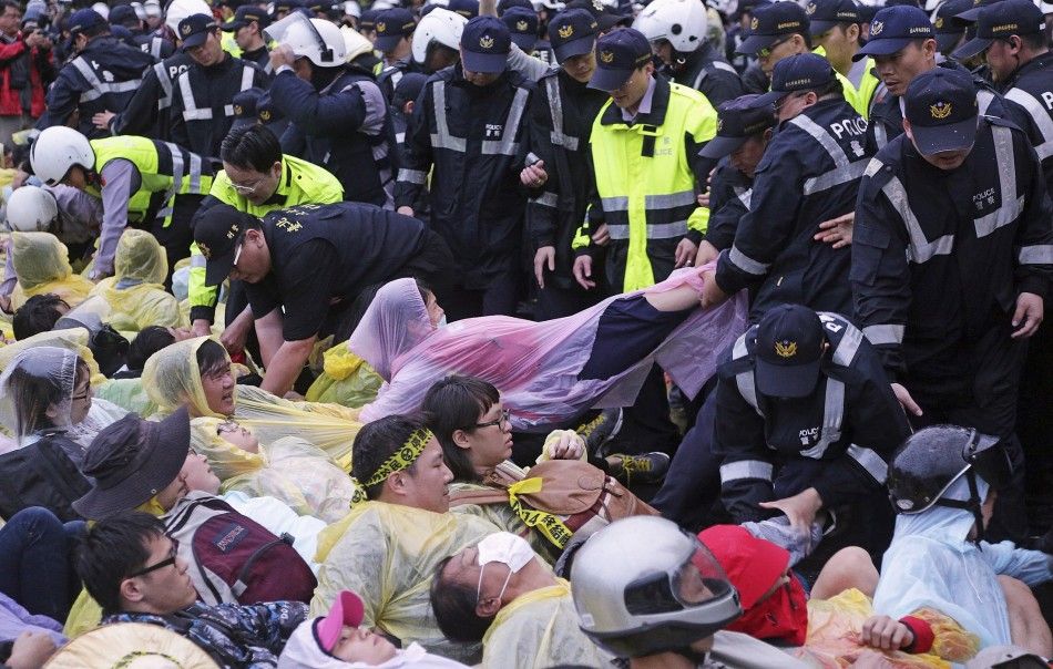 Police officers carry demonstrators during a protest against the construction of a fourth nuclear plant, in front of Taipei Railway station in Taipei April 28, 2014. The Taiwan government will halt construction at the islands fourth nuclear power plant, 