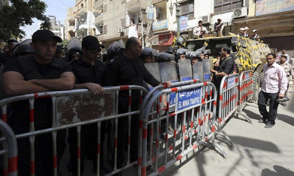 Security forces and riot police stand guard in front of relatives and families of members of the Muslim Brotherhood and supporters of ousted President Mohamed Mursi, as the sentence is handed to Muslim Brotherhood leader Mohamed Badie and other Brotherhoo