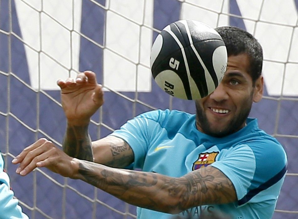 Barcelonas Dani Alves plays with a rugby ball during a training session at Ciutat Esportiva Joan Gamper training camp in Sant Joan Despi, near Barcelona April 15, 2014. Barcelona and Real Madrid will play their Kings Cup final soccer match on Wednesday.