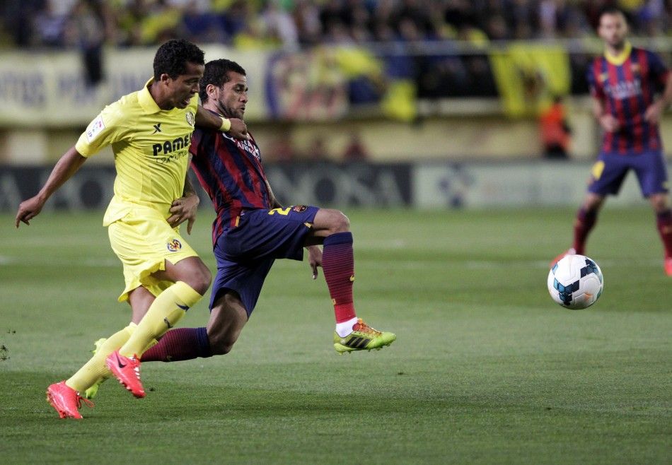 Barcelonas Dani Alves and Villarreals Giovani Dos Santos fight for the ball during their Spanish first division soccer match at the Madrigal stadium in Villarreal, April 27, 2014. REUTERSHeino Kalis