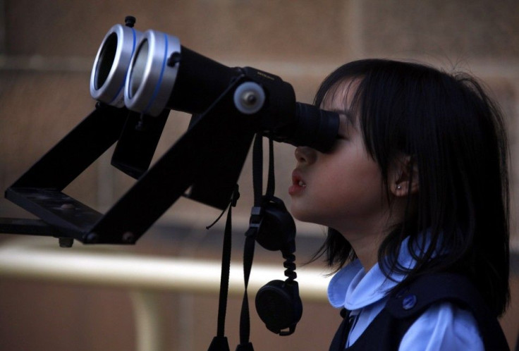 A girl looks through a telescope to try and see a partial solar eclipse from Sydney's Observatory Hill April 29, 2014. Australia experienced a partial solar eclipse, with around two thirds of the sun obscured by the moon, during the late afternoon until s