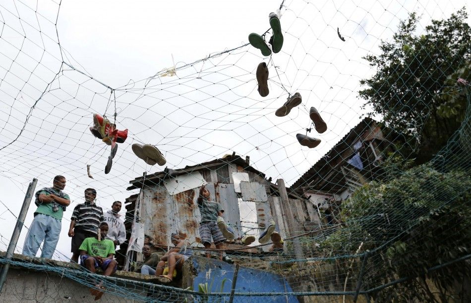Soccer shoes are seen on a fence as residents watch the Copa Popular soccer tournament, or Peoples Cup, held between slums, at the Santa Marta slum in Rio de Janeiro April 27, 2014. About 10 slums participated in the sporting event organized by the Peopl