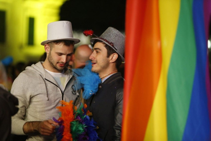 People wait for parliamentarians to vote on recognising same-sex partnerships in the square outside parliament in Valletta April 14, 2014. The Maltese parliament approved a law late on Monday to recognise same-sex partnerships on a legal par with marriage