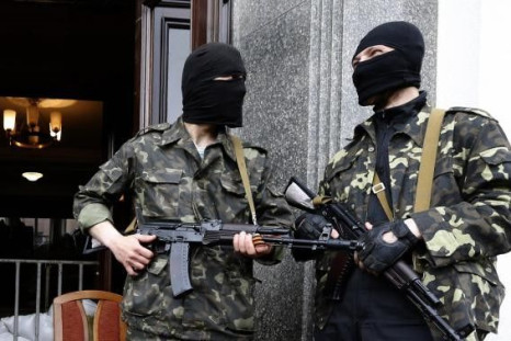 Pro-Russian armed men stand at the entrance to the regional government headquarters in Luhansk, eastern Ukraine, April 30, 2014.
