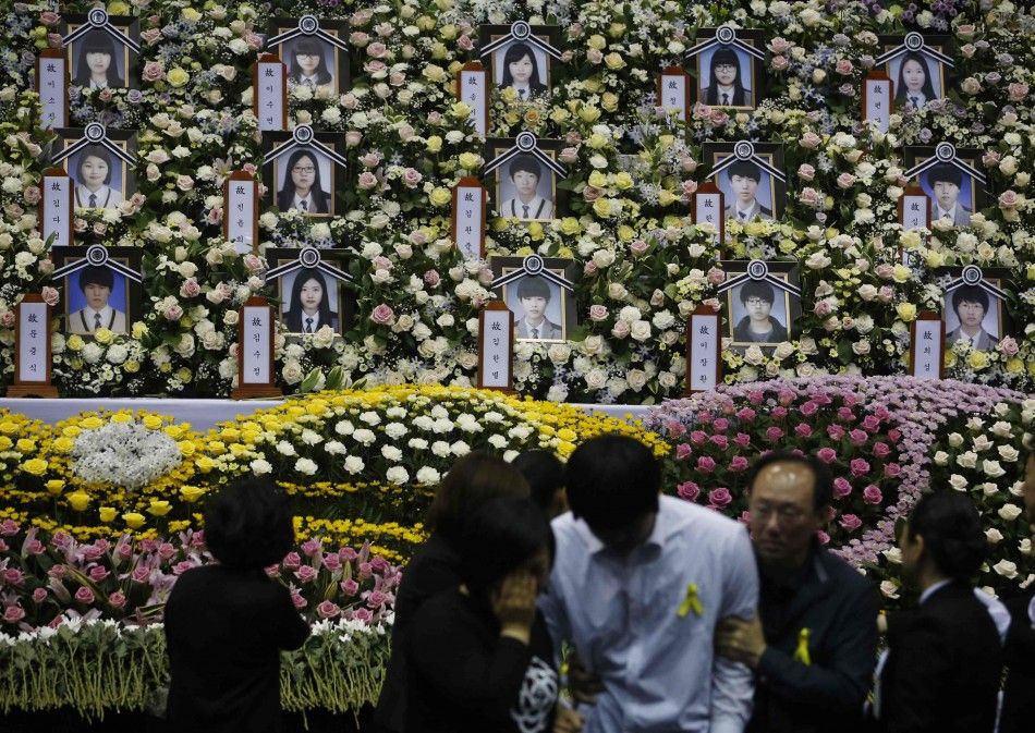 A student in white, who survived the Sewol ferry disaster and was discharged from a hospital, cries after paying tribute to victims of the sunken passenger ship, at the official memorial altar in Ansan April 30, 2014. The Sewol ferry sank on a routine t