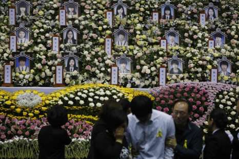 A student (in white), who survived the Sewol ferry disaster and was discharged from a hospital, cries after paying tribute to victims of the sunken passenger ship, at the official memorial altar in Ansan April 30, 2014. The Sewol ferry sank on a routine t