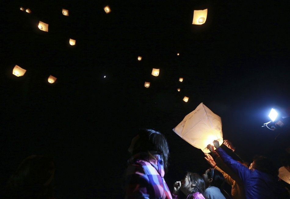 People and family members of missing passengers onboard the sunken passenger ferry Sewol release paper lanterns in memory of the missing and dead passengers, at a port where family members of missing passengers are gathered in Jindo May 6, 2014, on the oc
