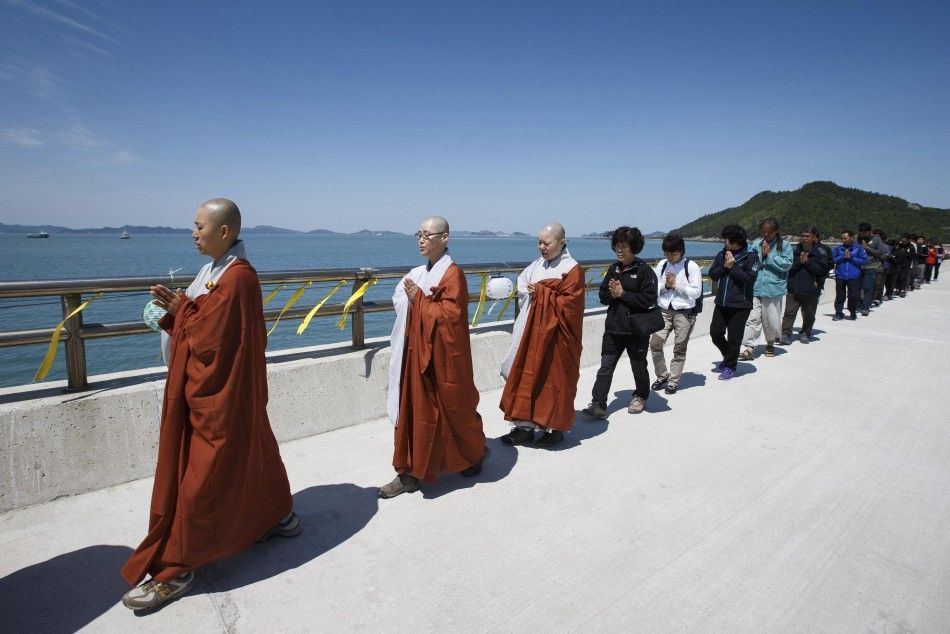Buddhist monks, believers and family members of the missing passengers onboard sunken passenger ferry Sewol march during a service in memory of the missing and dead passengers at a port in Jindo May 6, 2014, on the occasion of Buddhas birthday. REUTERSY