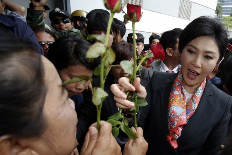 Thailands Prime Minister Yingluck Shinawatra is greeted by her supporters gathered outside the Permanent Secretary of Defence office in Bangkok May 7, 2014. A Thai court found Yingluck guilty of violating the constitution on Wednesday and said she had to