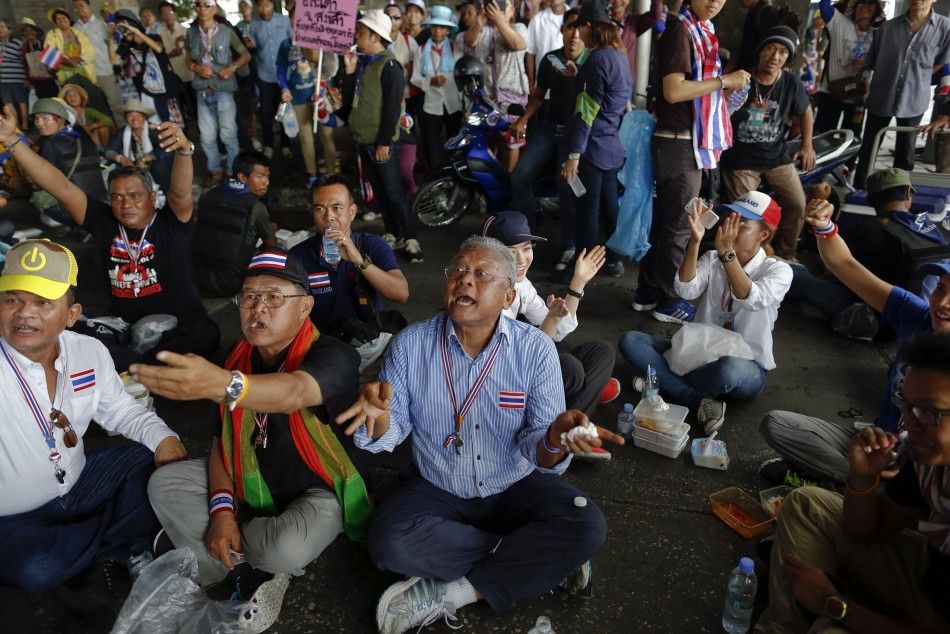 Anti-government protest leader Suthep Thaugsuban C reacts among his supporters as news about a Thai courts verdict regarding Prime Minister Yingluck Shinawatra is told to him in Bangkok May 7, 2014. The Thai court found Yingluck guilty on Wednesday of 