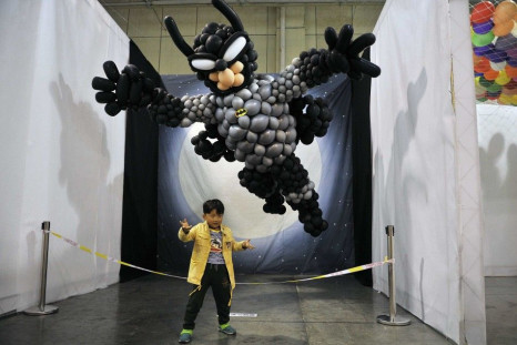 A Boy Poses for Photographs in Front of a Replica Batman Made of Balloons at a Balloon-themed Carnival in Hefei