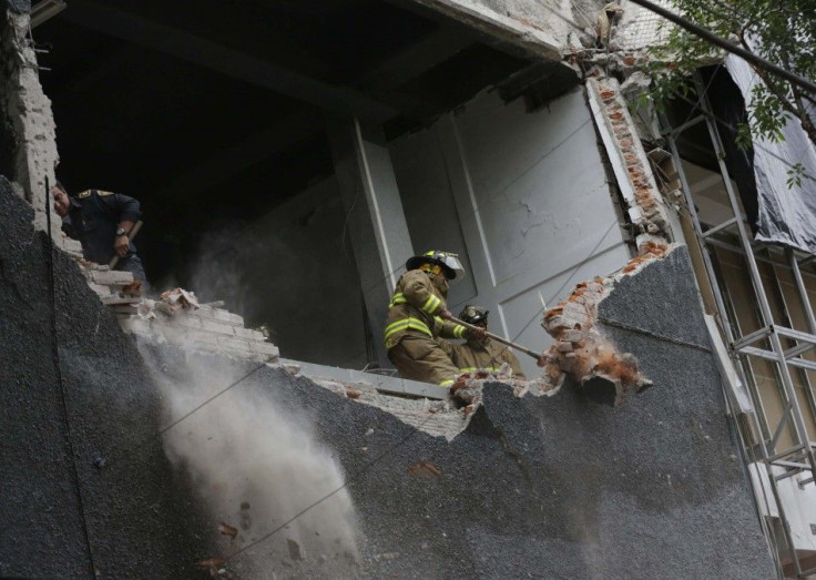 A firefighter works to demolish a damaged wall of a building after a 6.4 magnitude earthquake in Mexico City May 8, 2014. The earthquake shook Mexico City on Thursday, rattling buildings and prompting office evacuations. The U.S. Geological Survey put the