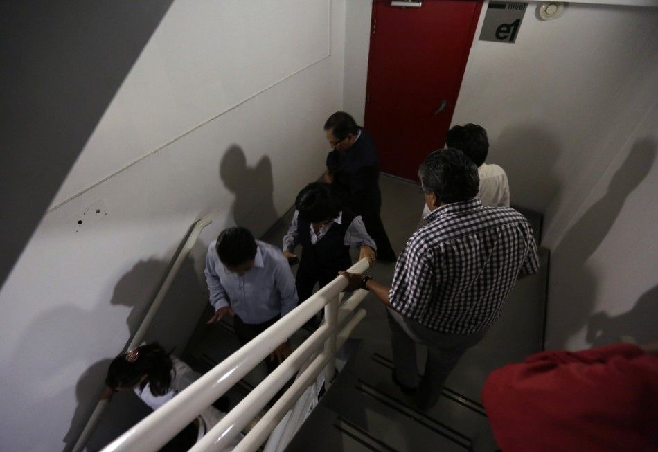 People walk down the stairs of a building after a 6.8 magnitude earthquake in Mexico City May 8, 2014. A 6.8 magnitude earthquake shook Mexico City on Thursday, rattling buildings and prompting offices to be evacuated, but there were no immediate details 