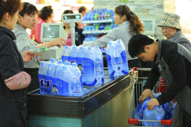 People buy bottled water at a supermarket in Lanzhou, Gansu province, April 11, 2014. Residents in the Chinese city of Lanzhou rushed to buy bottled drinks on Friday after authorities said benzene, a cancer-inducing chemical, had been found in tap water a
