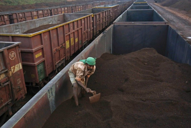 A worker levels the iron ore in a freight train at a railway station at Chitradurga in the southern Indian state of Karnataka in this November 9, 2012 file photo. One of Indian prime ministerial hopeful Narendra Modi's main election planks is to crank up 