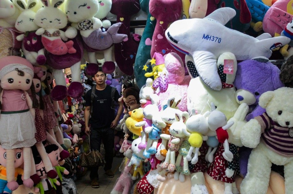 A man looks up as a stuffed toy of Malaysia Airlines MH370 is on sale at a store in Guangzhou, Guangdong province, May 11, 2014. Picture taken May 11, 2014. REUTERSAlex Lee