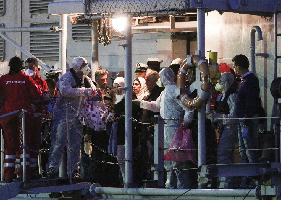 Migrants and members of the crew are seen aboard of the Italian frigate quotGrecalequot as they arrives at the Catania harbour in the Italian island of Sicily May 13, 2014. Italian naval and coast guard vessels recovered 14 bodies and rescued around 2