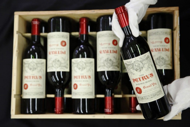 An employee poses with a case of twelve bottles of &quot;Petrus 1988&quot; wine owned by Ferguson, at Christie&#039;s auction house in London