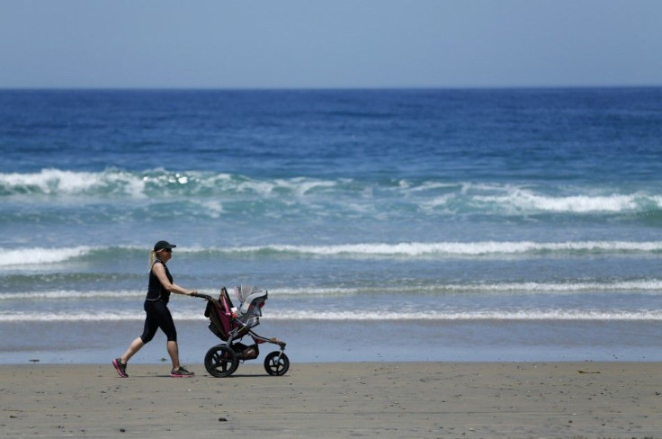 A woman takes her baby out for a stroll along the beach in La Jolla, California May 12, 2014.  REUTERS/Mike Blake