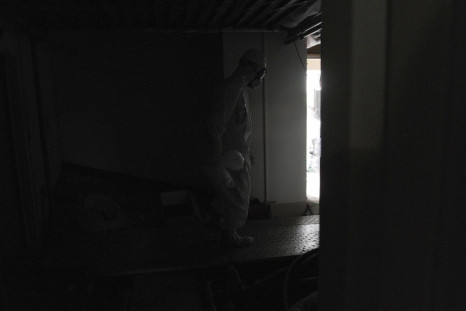 Wearing a protective suit and a mask, an employee of Japan's Tokyo Electric Power Co. (TEPCO) walks carefully along a dark aisle after U.S. Ambassador to Japan Caroline Kennedy visited the central control room for the unit one and unit two reactors at TEP
