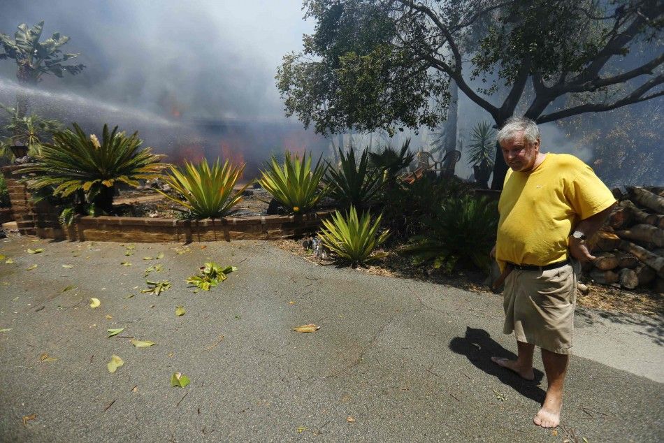 Greg Saska watches as his mothers home goes up in flames as fire fighters battle wildfires in Carlsbad, California  May 14,  2014.     REUTERSMike Blake
