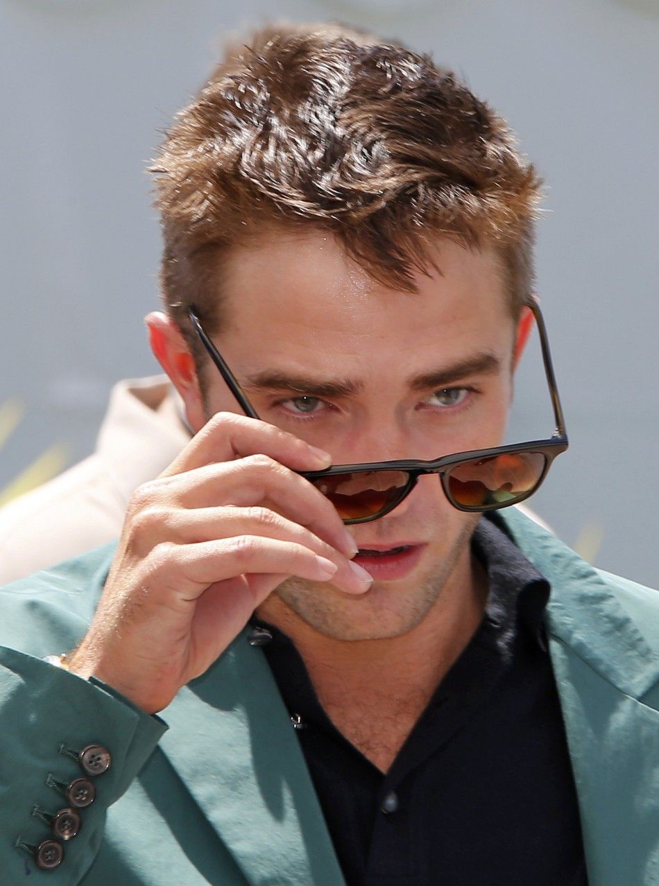 Cast member Robert Pattinson removes his sunglasses as he arrives to attend a photocall for the film quotThe Roverquot out of competition at the 67th Cannes Film Festival in Cannes