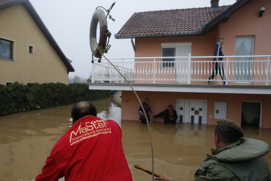 REFILE - CORRECTING DIRECTION OF TOWN FROM BELGRADE  A man throws a life buoy towards people waiting to be evacuated from a flooded house in the town of Obrenovac, southwest of Belgrade May 16, 2014. The heaviest rains and floods in 120 years have hit Bos