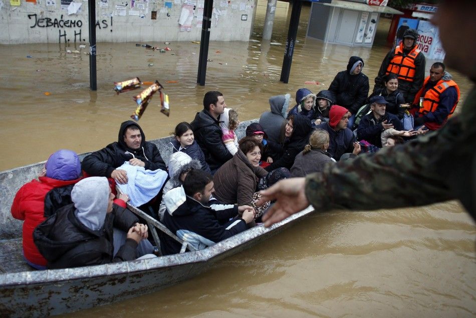 REFILE - CORRECTING DIRECTION OF TOWN FROM BELGRADE  A Serbian army soldier throws candy bars to people as they are evacuated a boat in the flooded town of Obrenovac, southwest of Belgrade, May 17, 2014. Emergency services pulled seven dead bodies from fl