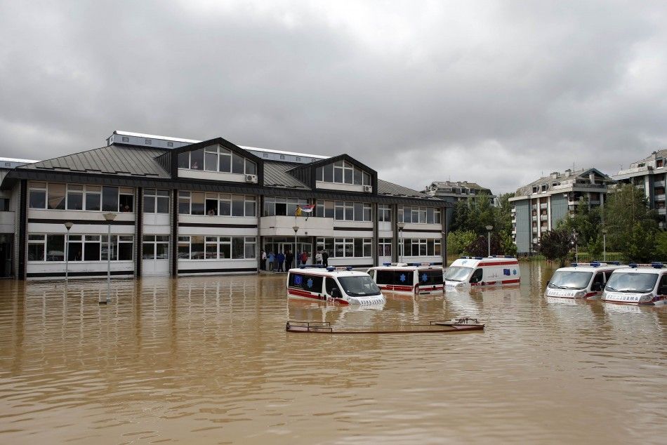 Ambulances are seen half submerged in floodwaters in front of a school in the flooded town of Obrenovac, southwest of Belgrade May 17, 2014. Seven bodies were pulled from flooded homes in Bosnia and the army rushed to free hundreds of people stranded in a