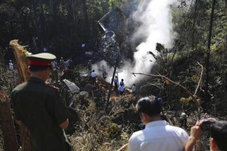 Rescue workers search an air force plane crash site near Nadee village, in Xiang Khouang province in the north of the country May 17, 2014. The Laotian air force plane with at least 14 people on board crashed on Saturday, a defence ministry source said, a
