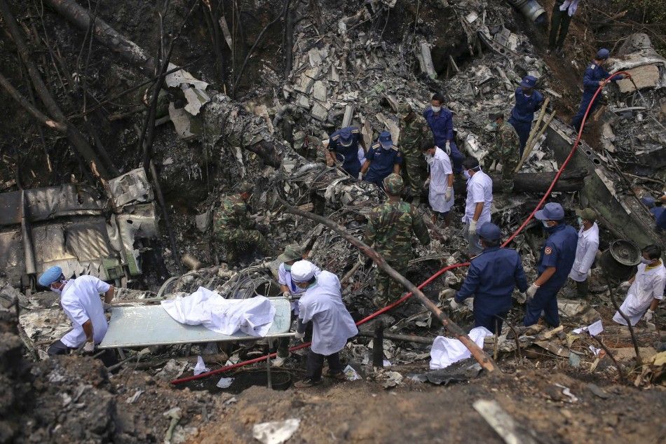 Rescue workers search an air force plane crash site near Nadee village, in Xiang Khouang province in the north of the country May 17, 2014. The Laos air force plane with 14 people on board, including the defence minister, has crashed in the north of the S