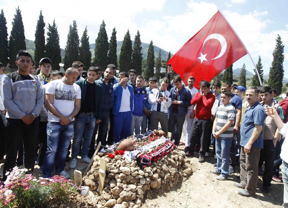 People mourn at graves for miners who died in Tuesdays mine disaster, at a cemetery in Soma, a district in Turkeys western province of Manisa May 18, 2014. Turkish police have detained 18 people, including mining company executives and personnel, as par