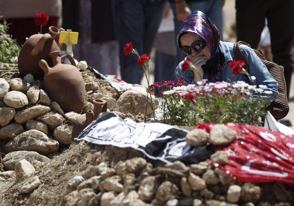 A woman mourns at graves for miners who died in Tuesdays mine disaster, at a cemetery in Soma, a district in Turkeys western province of Manisa May 18, 2014. Turkish police have detained 18 people, including mining company executives and personnel, as p