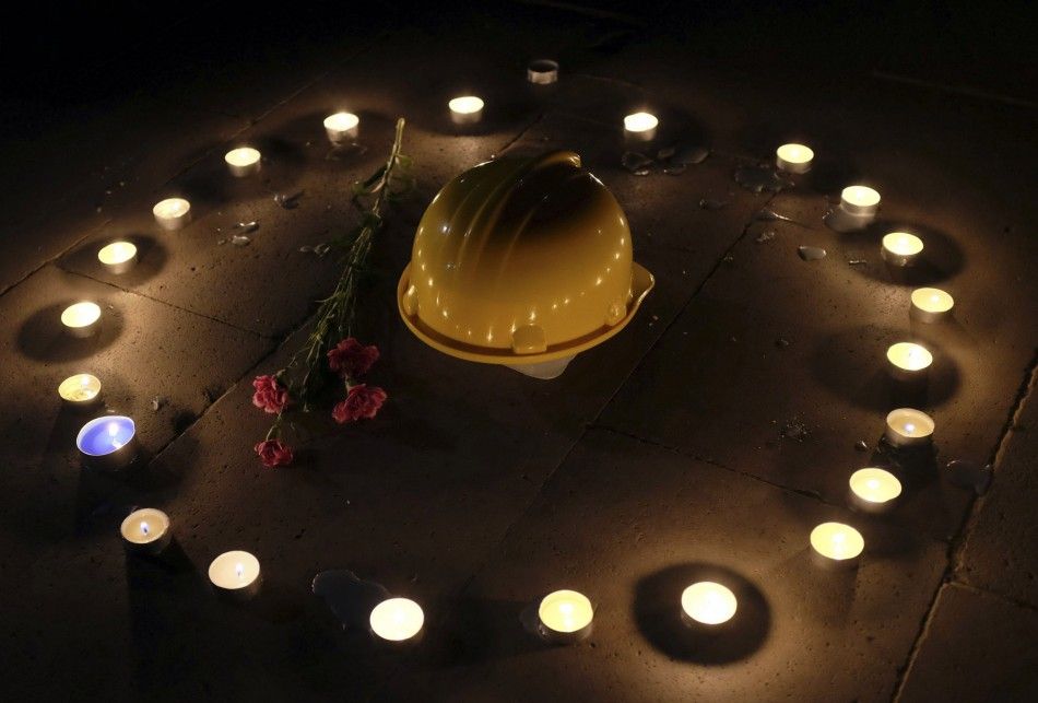A mining helmet and carnations are seen placed on the ground by demonstrators during a candlelight vigil for the victims of the Soma mining disaster in western Turkey, in Istanbul May 18, 2014. A Turkish court ordered three suspects to be kept in custody 