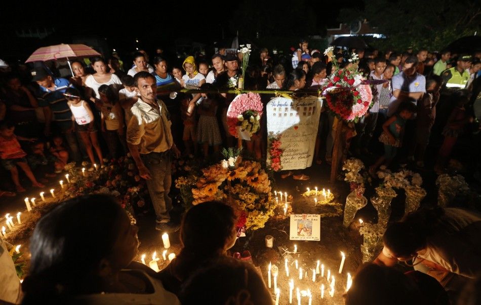 Relatives and residents light candles, in memory of the children who died in a burning bus, at the site of the accident in Fundacion, northern Colombia, May 19, 2014. Thirty-one children and one adult were killed in Colombia on Sunday when fuel exploded o