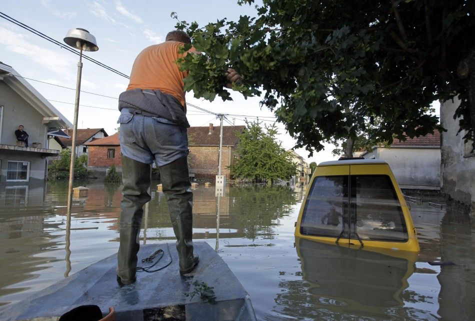 A man navigates a boat along a street during heavy floods in Bosanski Samac May 19, 2014. Bosnia said on Monday that more than a quarter of its 4 million people had been affected by the worst floods to hit the Balkans in living memory, comparing the quot