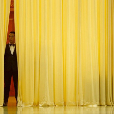 A hotel employee stands behind a curtain before Malaysia's Defence Minister Hishammuddin arrives for a news conference near Kuala Lumpur